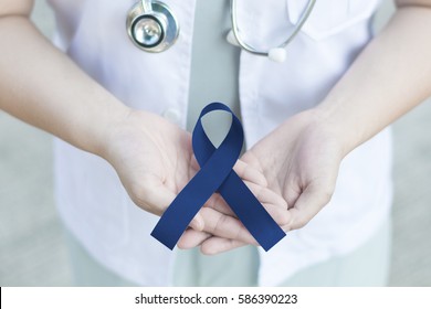 Doctor in white uniform with royal dark navy blue ribbon awareness in hand for
Acute Respiratory Distress Syndrome (ARDS), Arthritis, Chronic Fatigue Syndrome, Colitis, Colon, Colorectal Cancer.