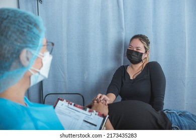 A doctor and the wife of a patient have small talk together. Having a lighthearted conversation to diffuse a tense situation at the emergency ward of a hospital. - Shutterstock ID 2173435283
