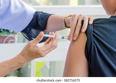 doctor woman giving a child injection in arm.