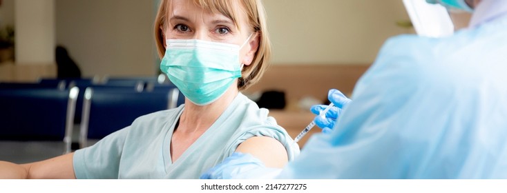 Doctor Woman Holding Syringe And Injection Vaccine Patient Elderly In Face Mask For Prevention Coronavirus At Hospital, Vaccination For Pandemic Of Senior, Infection And Immunization, Medical Concept.