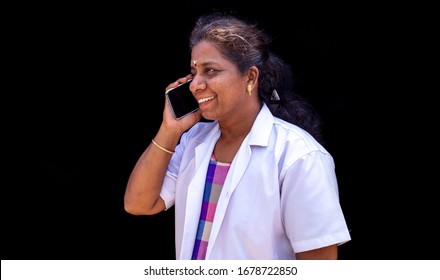 A Doctor Woman Isolated On Black Background. Female Doctor In White Medical Gown Talking