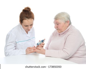 Doctor woman measuring glucose level blood test with glucometer and small drop of blood from iabetes patient senior on a white background