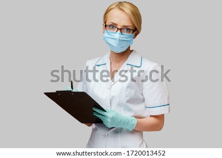 Doctor or woman nurse holding plane table and pen