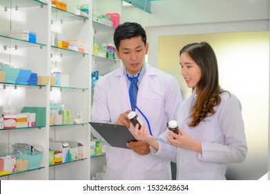 Serious Pharmacists Reaching Medications Among Shelves Stock Photo ...