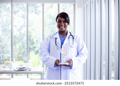 The doctor woman, physiotherapist is showing the Human Hand Skeleton Model on Base in the hospital. She prepares to treatment. - Powered by Shutterstock