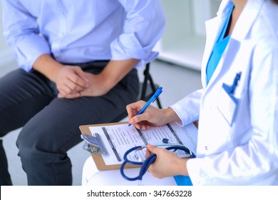 Doctor Woman Sitting With  Male Patient At The Desk