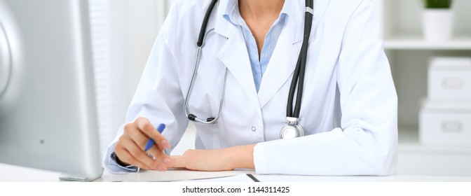 Doctor woman working with computer at hospital.  Closeup of stethoscope. Health care, insurance and help concept - Shutterstock ID 1144311425