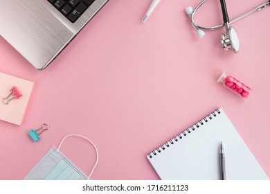 Doctor Work Place And Medical Equipment On Pink Background. Stethoscope, Laptop, Protective Face Mask, Thermometer, Pills, Note Pad And Pen On Table. Top View, Flat Lay, Frame, Copy Space
