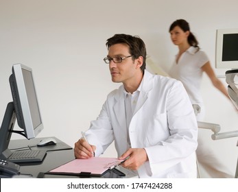 Doctor Working At Desk With Paperwork