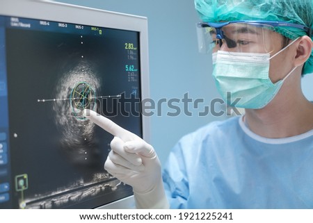 Doctor working at Intravascular ultrasound imaging (IVUS) at cardiac catheterization laboratory room.