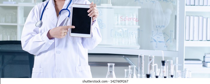Doctor working with laptop computer and writing on paperwork. Hospital background.  - Shutterstock ID 1427609267