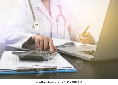 doctor working at office desk and calculator with computer.