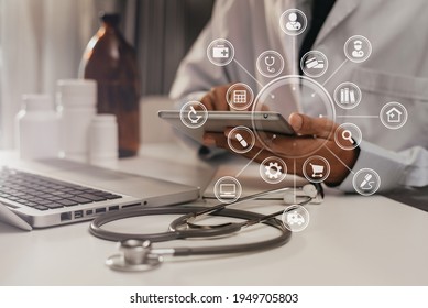 Doctor Working On Laptop Computer And Tablet And Medical Stethoscope On Clipboard On Desk, Electronics Medical Record System EMRs Concept.