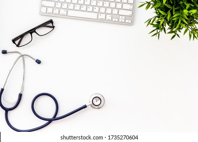 Doctor Workplace. Stethoscope And Computer Keyboard On White Office Desk From Above Copy Space