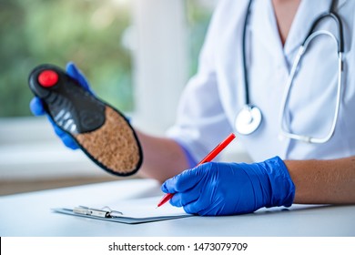 Doctor write out a medical prescription for orthopedic insoles for the treatment and prevention of flat feet. Foot care and wearing comfortable shoes