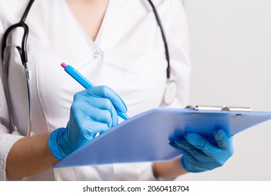 Doctor writes down patient medical history with pen on card - Shutterstock ID 2060418704