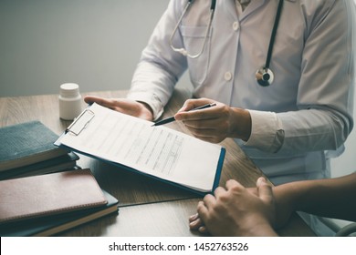 Doctor Is Writing The Appointment Letter To The Patient At The Clinic.