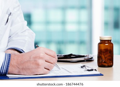 Doctor Writing Daily Report In His Office.