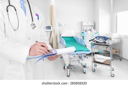 Doctor writing a medical prescription in hospital room