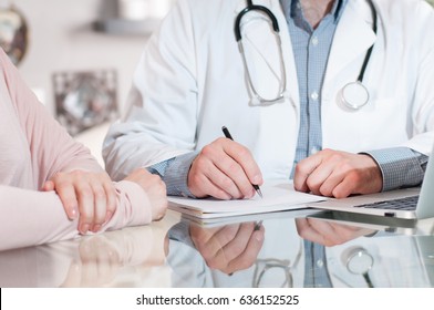 Doctor is writing prescription to patient