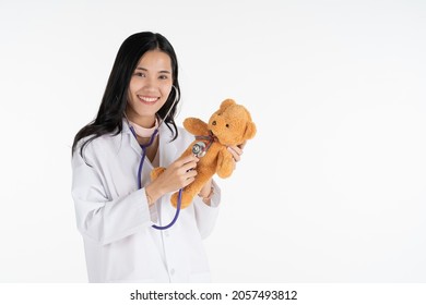 Doctor young asia woman, medical professional with stethoscope holding teddy bear in her hand with smile face.