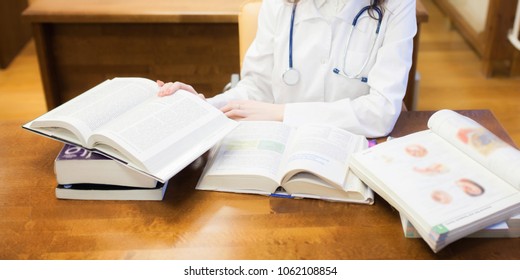 doctoral dissertation. a medical student for textbooks. The study of surgery by a beautiful girl in the library. Nurse. copy space