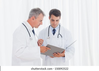 Doctors analyzing results together in bright office - Powered by Shutterstock