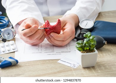 At doctors appointment physician shows to patient shape of thyroid gland with focus on hand with organ. Scene explaining patient causes and localization of diseases of thyroid and endocrine system