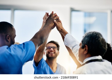 Doctors Celebrating Medical Success After Working Together As A Team And Give Each Other Motivating A High Five As A Group In A Hospital. Healthcare Workers Joining Hands In A Huddle Showing