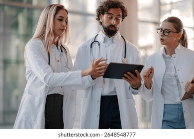 Doctors collaborating, using a tablet to analyze patient data, improving healthcare and treatment strategies