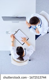 Doctors Discussing A Patient?s Diagnosis In An Office At A Table In Front Of A Computer. Top View, Flat Lay