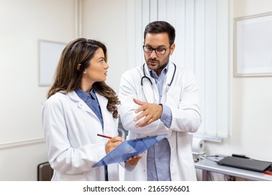 Doctors discussing over a medical report in hospital. Female and male doctor checking clinical report of patient online. Healthcare staff having discussion in a office of private clinic. - Powered by Shutterstock