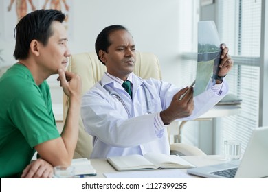 Doctors Discussing X-ray Of Patient With Compound Fracture