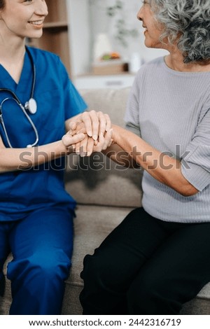 Doctors explain the use of medication to patients. Medical doctor holing senior patient's hands and comforting her on sofa at home