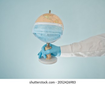 Doctor's Gloved Hand Holding Globe Wearing Mask