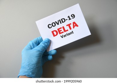 Doctor's hand in blue glove with white paper and text Covid-19 Delta Variant. Concept of medical variety delta variant and COVID-19. Concept words 'delta variant'. COVID-19 delta variant concept.