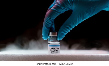 Doctor's Hand Holding Bottle Vaccine Covid-19 From Storage Box. Medication Treatment Concept.