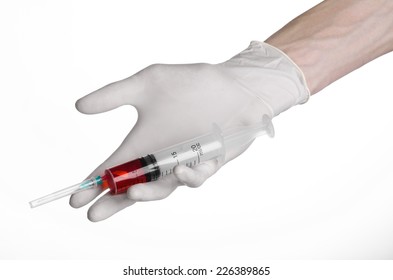 Doctor's hand holding a syringe, white-gloved hand, a large syringe, medical issue, the doctor makes an injection, white background, isolated, white gloves doctor, ebola test, red medication - Shutterstock ID 226389865