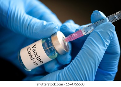 Doctor's hand holds a syringe and a blue vaccine covid19 bottle at the hospital. Health and medical concepts
