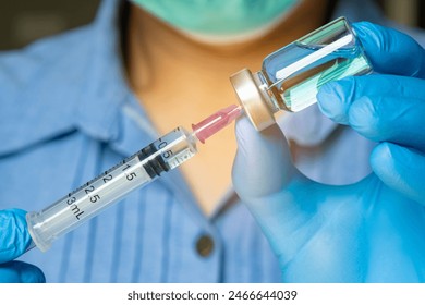 doctor's hand holds a syringe and a blue vaccine bottle at the hospital. Health and medical concepts.