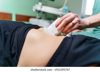 Doctor`s Hand Makes Abdominal Ultrasound To A Patient. Medical Research. Selective Focus From Side. Close-up.