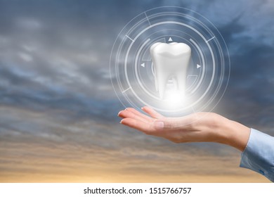 The doctor's hand shows a tooth on blurred sky background. - Shutterstock ID 1515766757