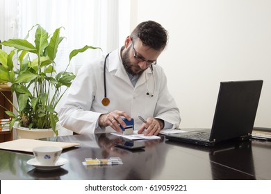 Doctor's Hand Stamped On The Prescription. The Doctor Writes A Prescription At His Desk. 