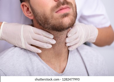 Doctor's Hand Wearing Gloves Performing Physical Exam Palpation Of The Thyroid Gland