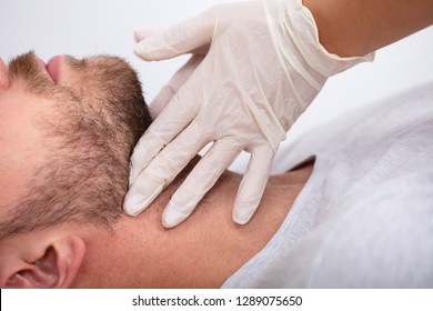 Doctor's Hand Wearing Gloves Performing Physical Exam Palpation Of The Thyroid Gland