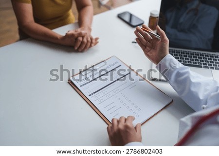 Doctor's hands explaining health assessment form to a patient during a medical consultation
