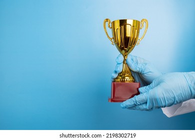 Doctor's Hands Holding Cup Of Medical Award