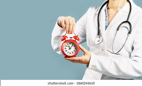 Doctors hands holding red alarm clock over blue background. Time is crucial life saver. Medical banner. Copy space. Book appointment or checkup time reminder. - Powered by Shutterstock