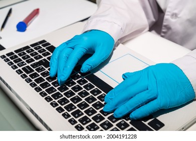 The Doctor's Hands In Medical Gloves Lie On The Keyboard. The Doctor Is Typing Text On The Computer. A Medical Worker Writes Out A Sick Leave Electronically.