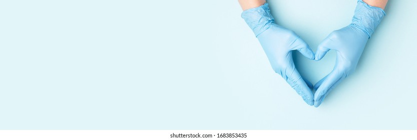 Las manos del doctor en guantes médicos en forma de corazón sobre fondo azul. Cartel para el sitio web con espacio de copia.